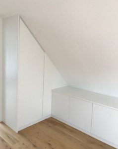 Weißer Einbauschrank in Dachschräge mit seitlichem Sideboard